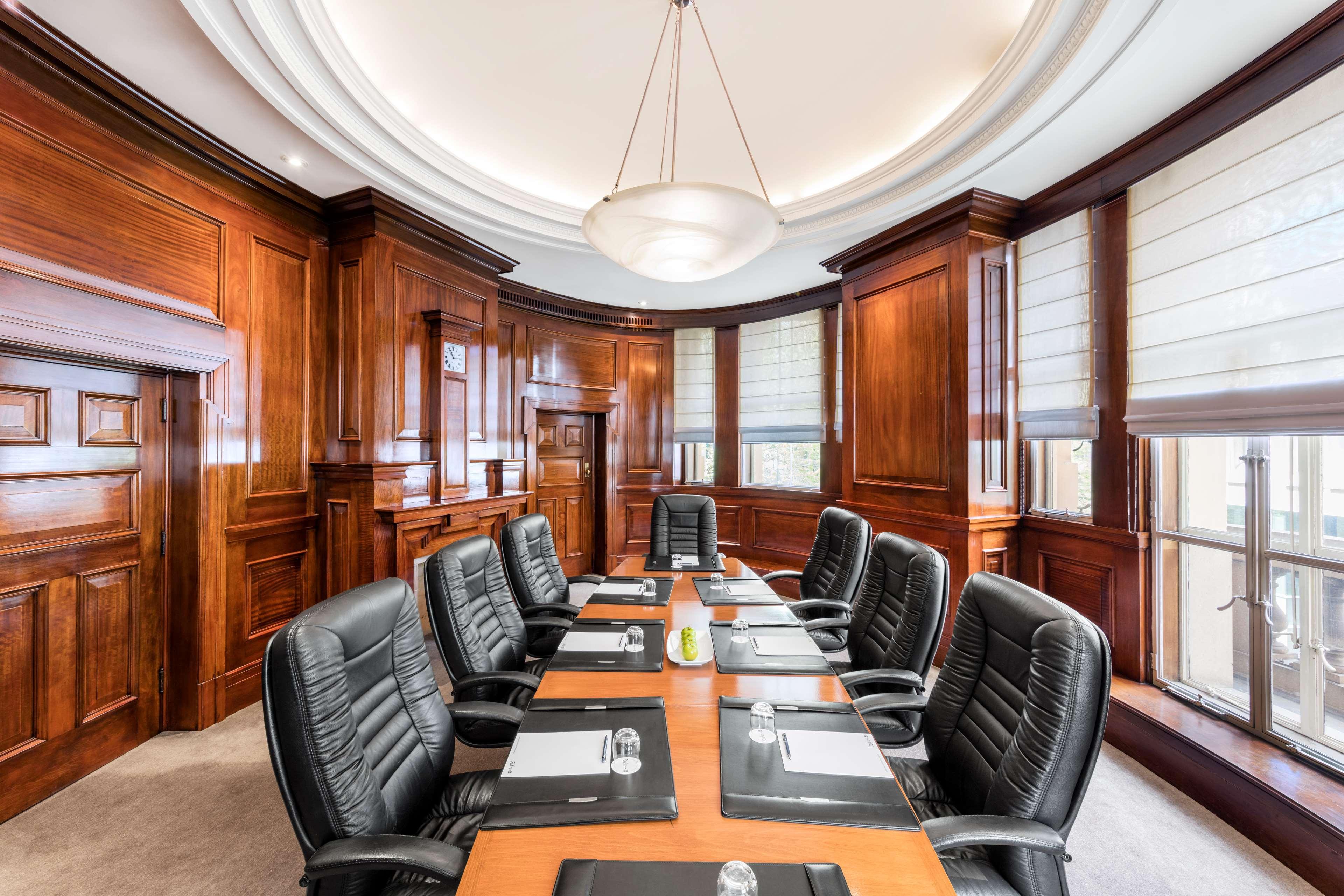 Radisson Blu Plaza Hotel ซิดนีย์ ภายนอก รูปภาพ The photo depicts a conference room featuring an elegant, professional design. The room is characterized by rich wooden paneling on the walls, creating a warm and sophisticated atmosphere. A large, rectangular table is situated in the center, with se