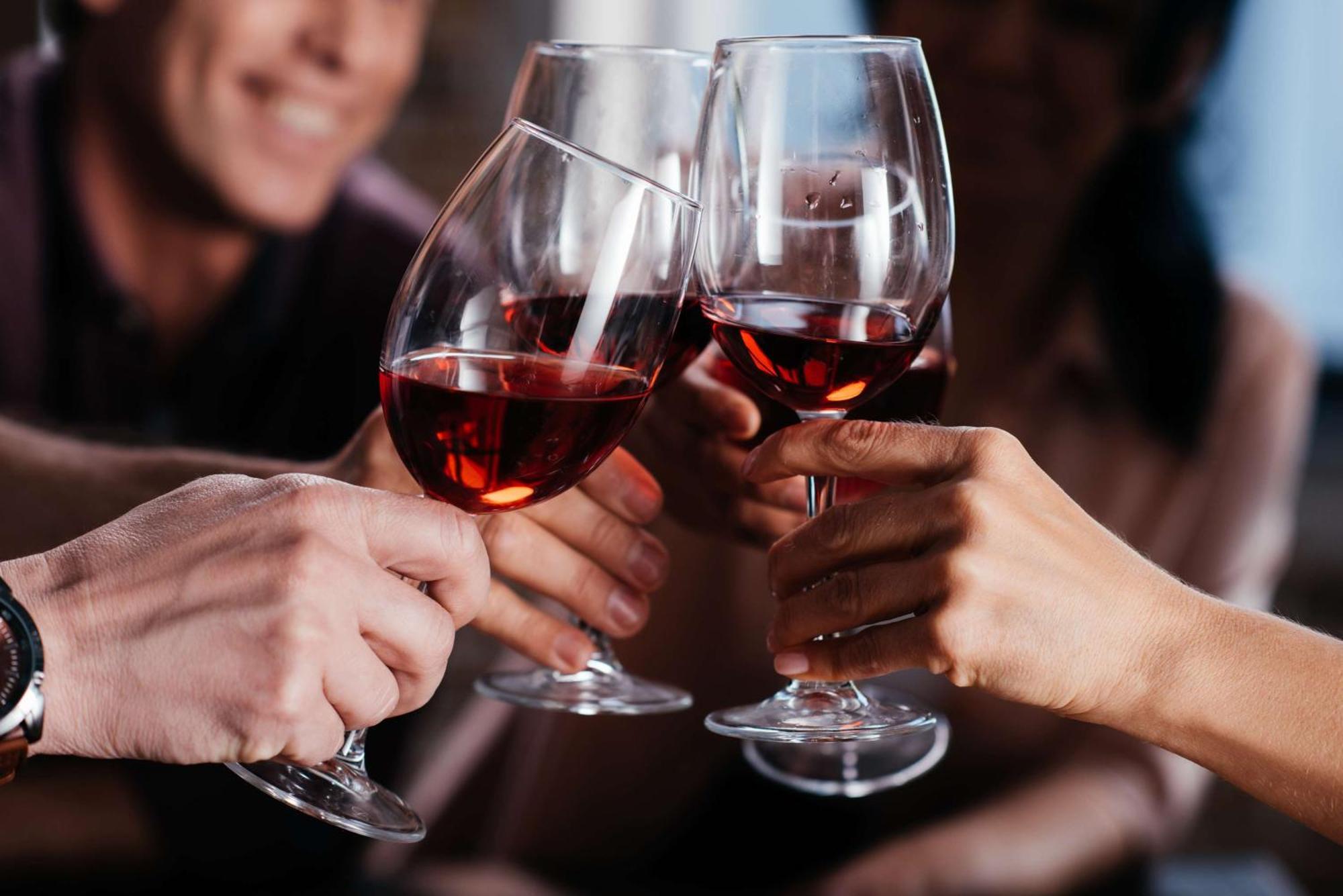 Radisson Blu Plaza Hotel ซิดนีย์ ภายนอก รูปภาพ The photo depicts a group of people celebrating or toasting with glasses of red wine. There are several glasses clinking together in a toast, suggesting a moment of joy or camaraderie. The background is slightly blurred, emphasizing the action of the